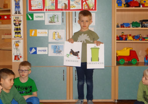 Chłopiec zTropicieli pokazuje planszę segregacji śmieci